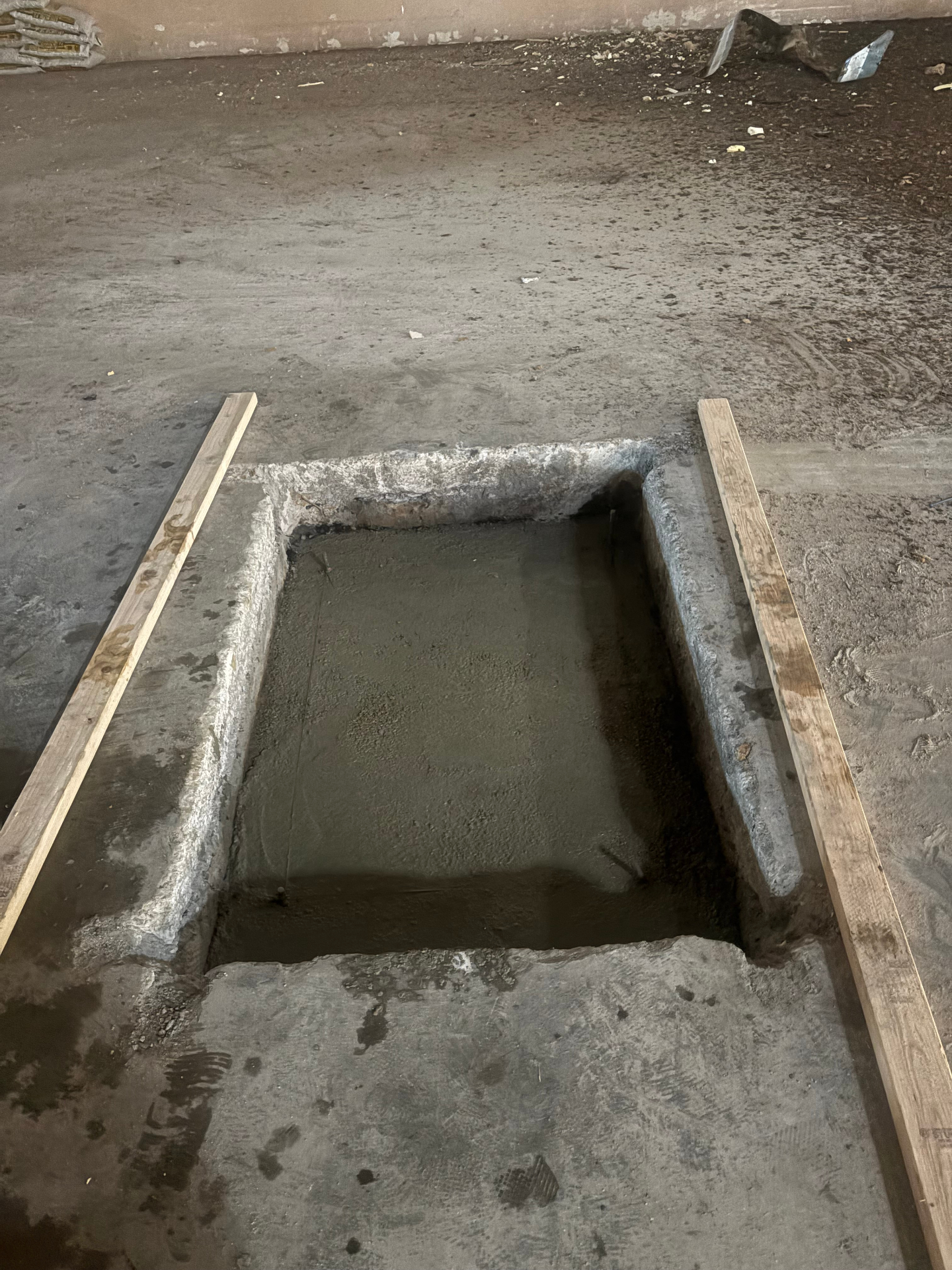 Aero Ranch construction — freshly poured pole vault box footing set into the slab.