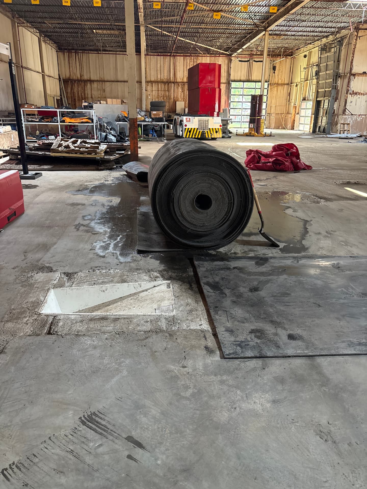 Aero Ranch construction — roll of runway belting staged on the warehouse floor.